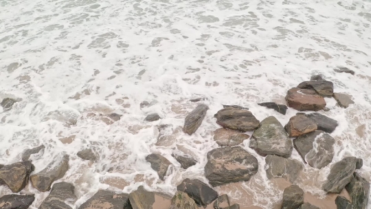 Beach waves crashing over Rocks